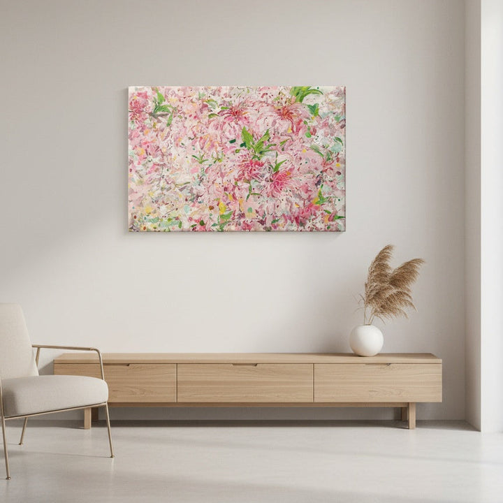 Floral painting on a wall above a wooden console table in a room.